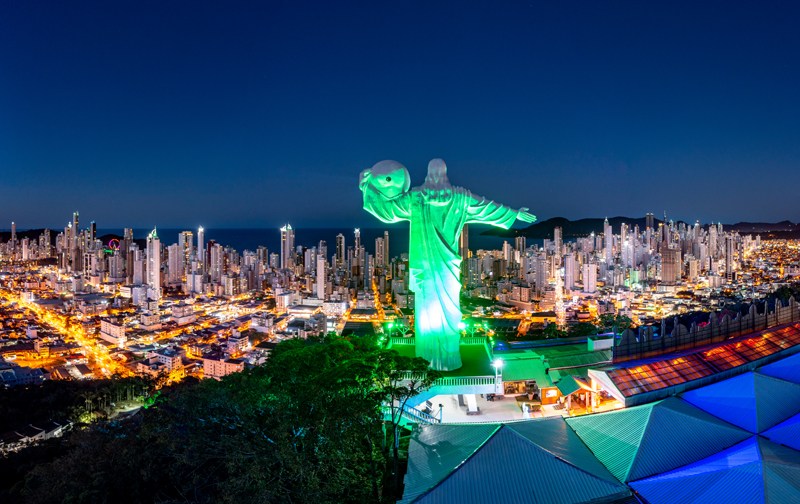 Cristo Luz iluminado, com Balneário Camboriú ao fundo